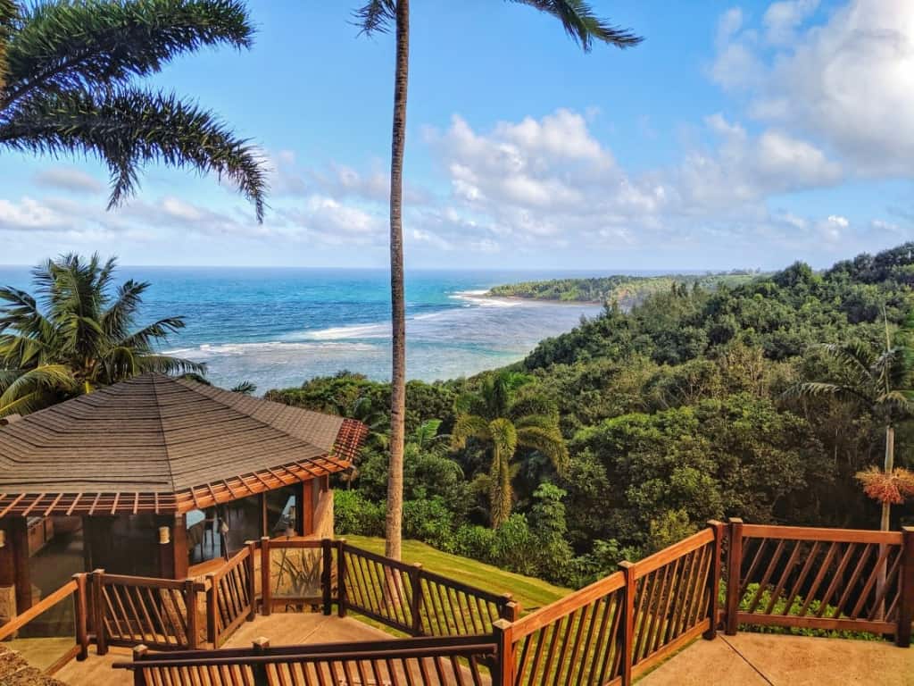 image depicts a Hawaiian resort overlooking forested hills and ocean in the distance