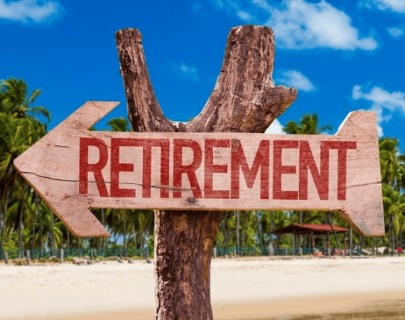 Image of a arrow-shaped sign with the word "Retirement" on it nailed to a tree trunk. Background features a beach with tropical palm trees.